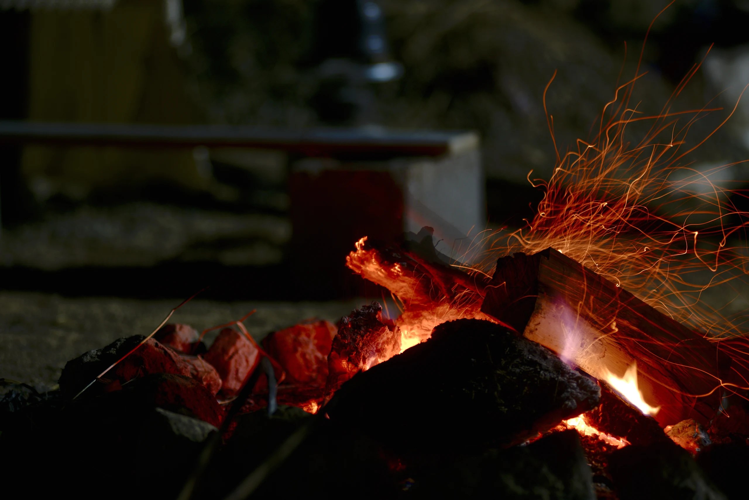 Burning wood and bright sparks from a fire at night.